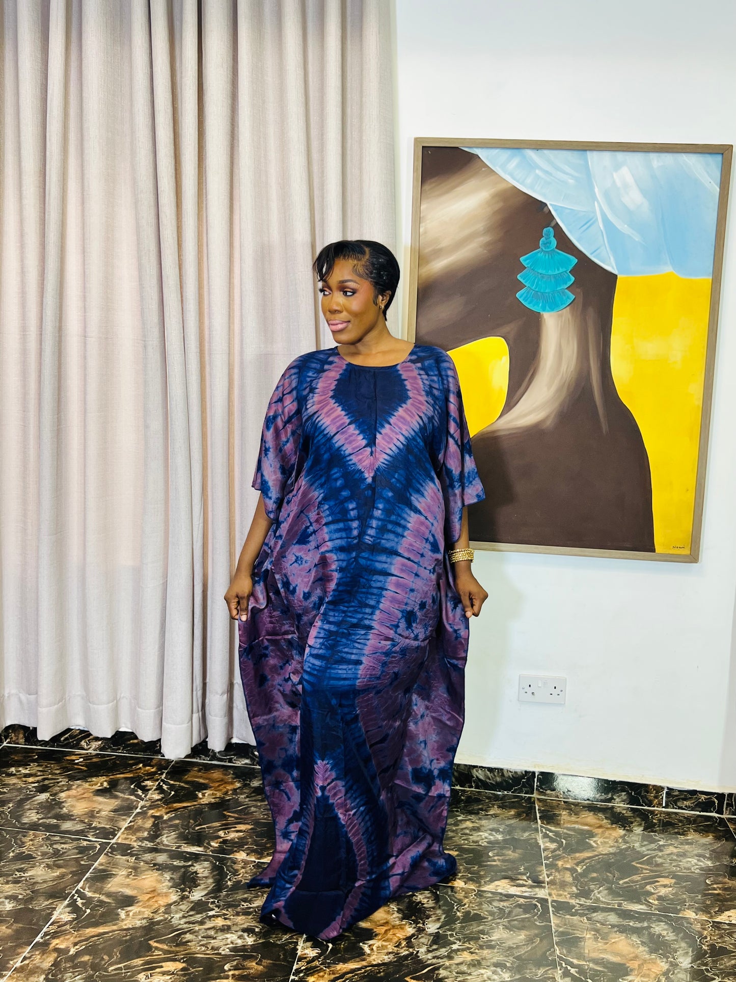 African woman wearing a handmade silk adire boubou dress – full-length traditional kaftan for women