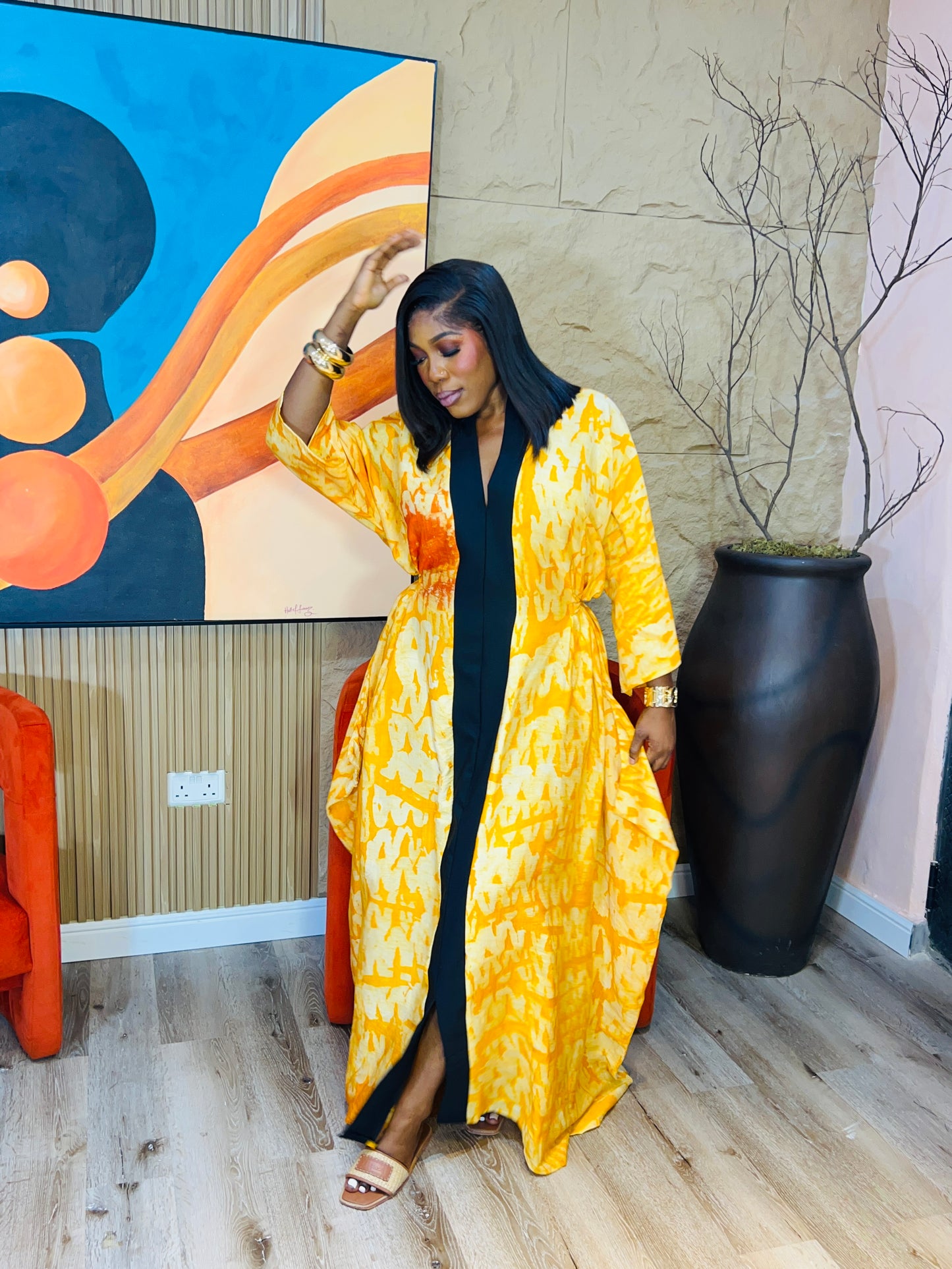 Woman wearing green Adire Crepe boubou with belt.