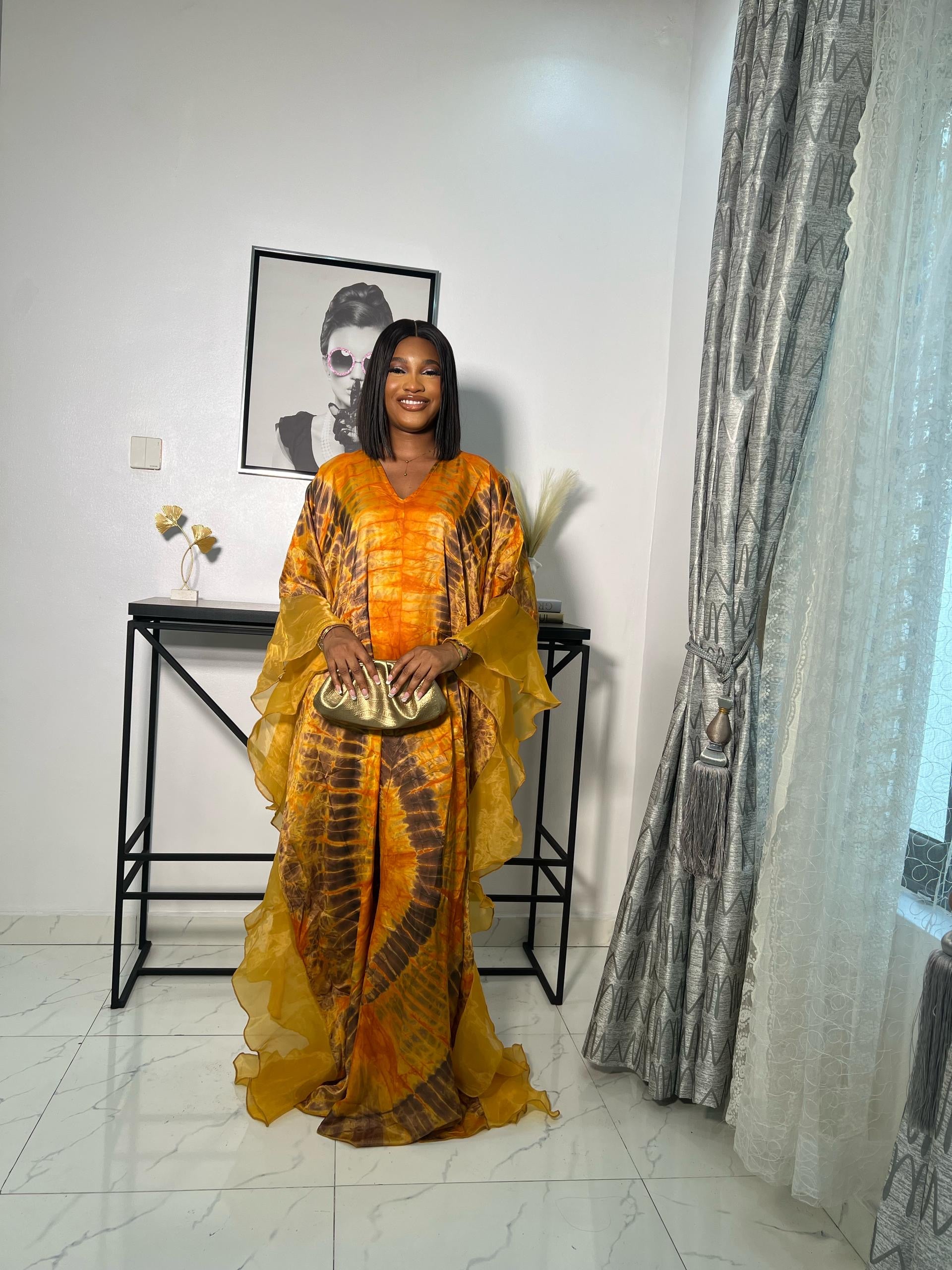 Elegant African woman in silk Adire boubou dress styled for a cultural event or casual day out