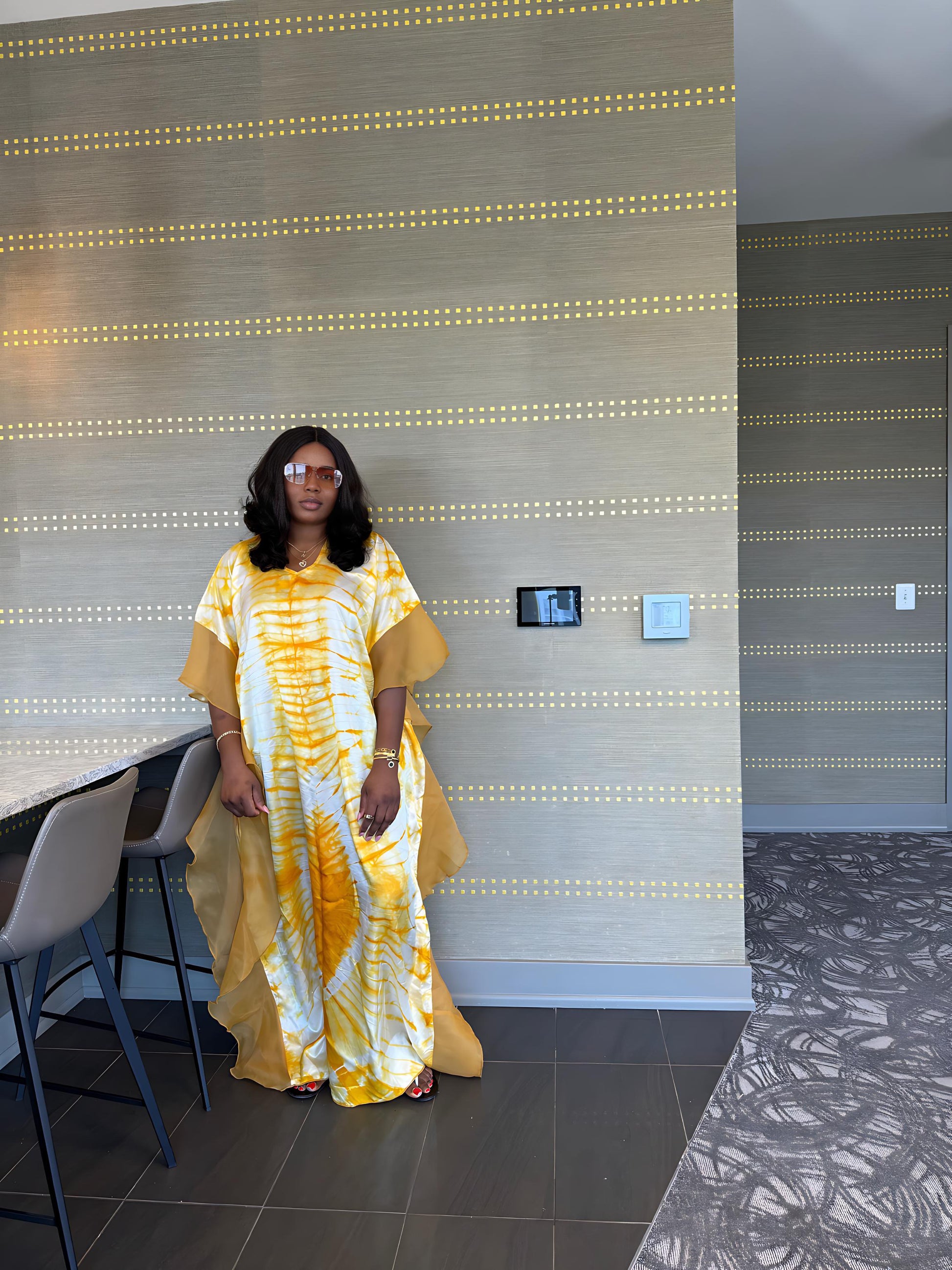 Elegant African woman in silk Adire boubou dress styled for a cultural event or casual day out