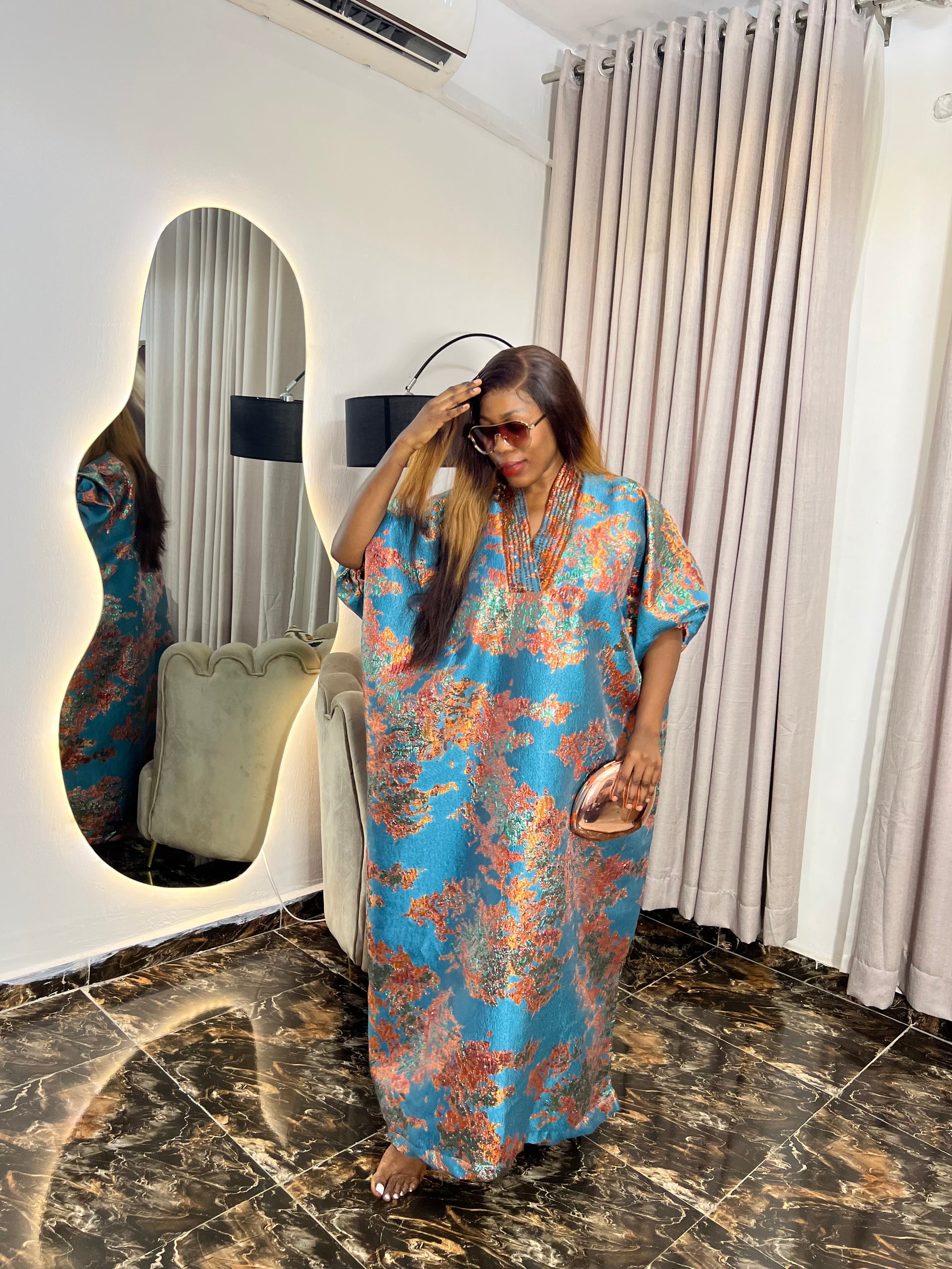 African woman in brocade boubou dress with crystal bead detail