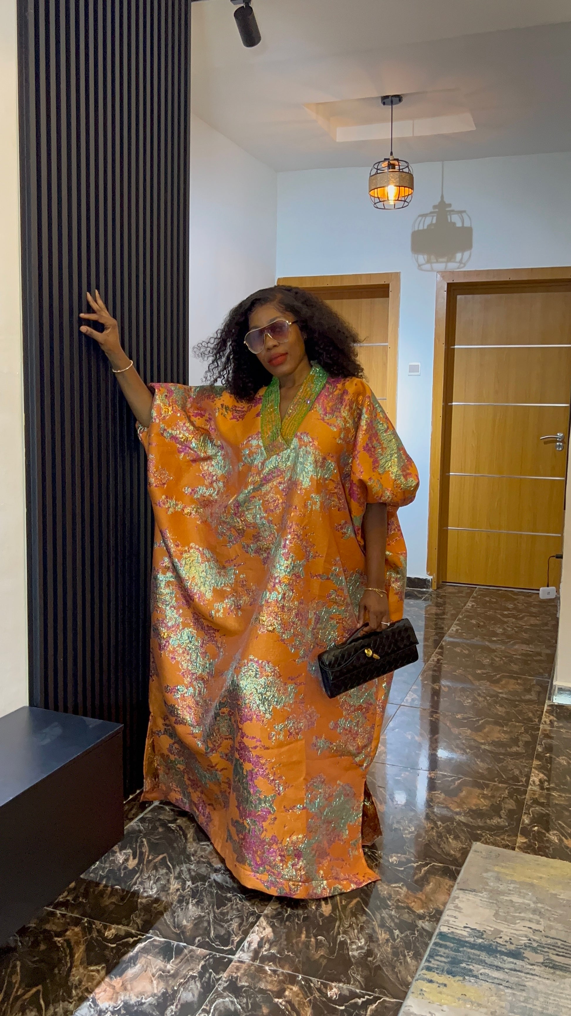 African woman in brocade boubou dress with crystal bead detail