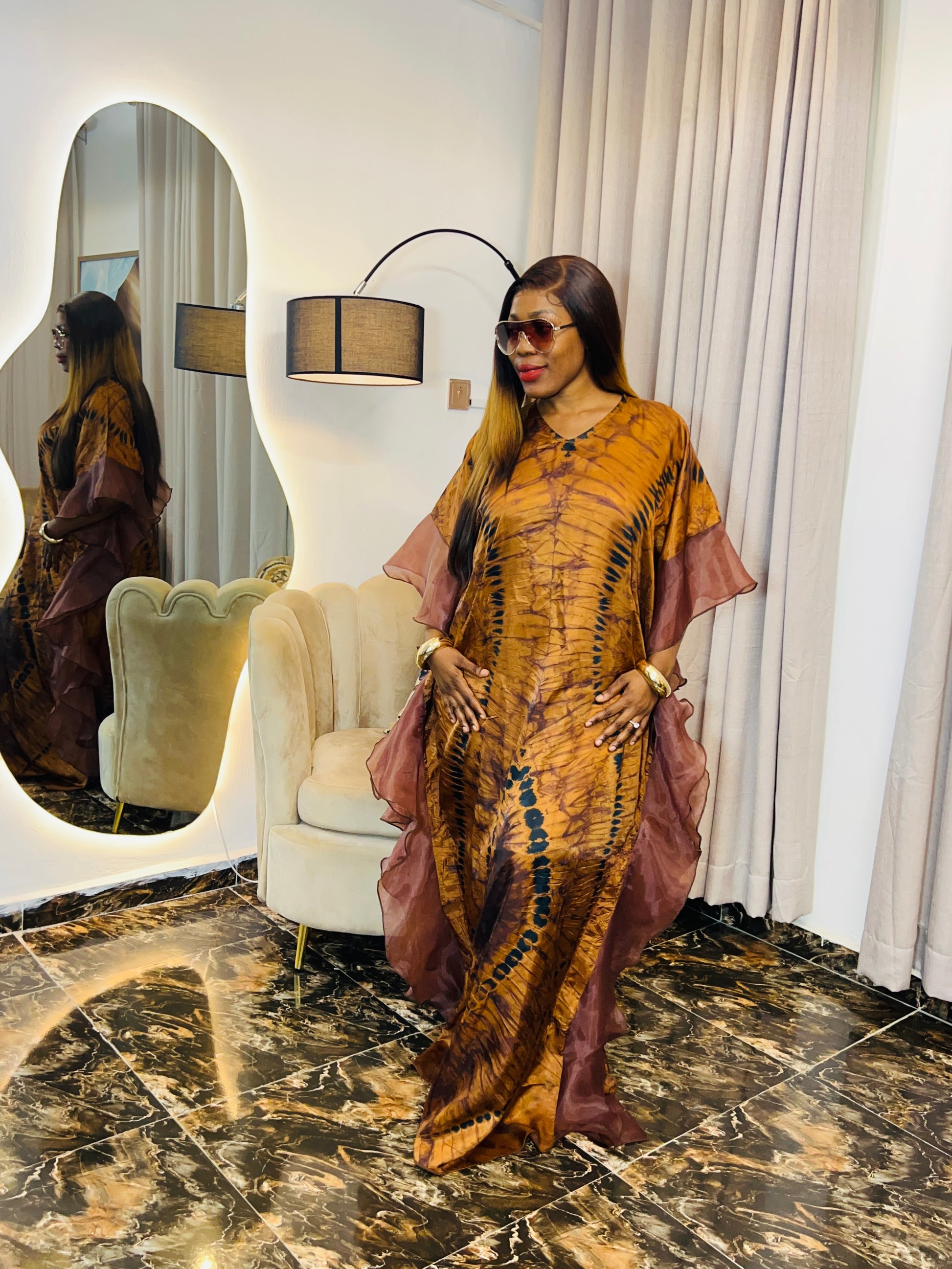 Elegant African woman in silk Adire boubou dress styled for a cultural event or casual day out