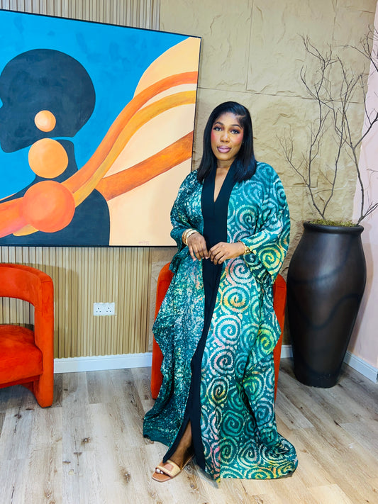 Woman wearing green Adire Crepe boubou with belt. 